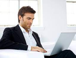 Человек во френче сидит за ноутбуком; деловой стиль; ПК и электроника.